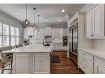 Bright kitchen boasts white cabinetry, marble countertops, stainless steel appliances, and hardwood floors at 4206 Whitby Se Way # 15, Smyrna, GA 30080