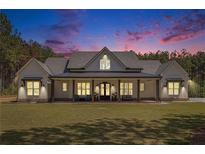 Stunning white farmhouse exterior featuring a large porch and professionally landscaped front yard, perfect for southern living at 2925 Old Broadnax Mill Rd, Loganville, GA 30052