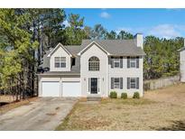 Charming two-story home featuring a two-car garage, classic architectural details, and mature trees at 4150 Soaring Dr, Douglasville, GA 30135