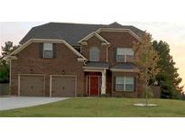 Charming two-story brick home featuring a well-manicured lawn and a two-car garage at 1211 Chapel Estates Way, Dacula, GA 30019