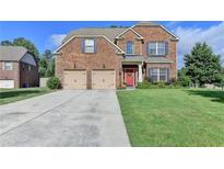 Inviting two-story brick home featuring a red front door, attached two-car garage and well-maintained lawn at 1211 Chapel Estates Way, Dacula, GA 30019