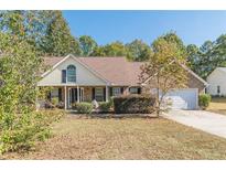 Charming single-story home with a well-maintained front yard and attached two car garage at 320 Creekside Trl, Covington, GA 30016