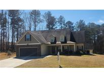 Charming home featuring a two-car garage, stone accents, and a well-maintained front yard at 275 Bridgemill Dr, Douglasville, GA 30134