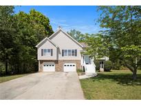 Charming two-story home features a two-car garage, lovely front yard, and a welcoming entrance with white stairs at 221 Makayla Way, Temple, GA 30179
