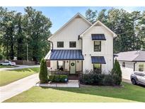 Charming two-story modern farmhouse with manicured front lawn, porch, and black window and door accents at 517 Daniel Ave, Decatur, GA 30032