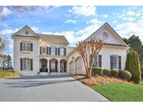 Charming two-story home with white brick, black shutters, covered porch and a well-manicured lawn at 6640 Eastleigh Cir, Suwanee, GA 30024