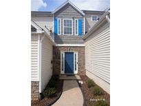 Charming home featuring a blue front door, stone accents, and light-colored siding, creating a welcoming entrance at 1510 Paramount Ln, Sugar Hill, GA 30518