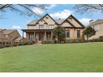 Charming two-story home with a covered front porch, landscaped yard, and a well-manicured lawn at 3060 Salisbury Ln, Cumming, GA 30041