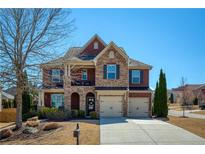 Charming two-story brick home with a well-manicured lawn, two car garage and stone accents at 6125 Allison Rd, Cumming, GA 30040
