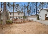 Charming two-story home featuring a wooden deck, attached garage, and beautiful landscaping at 1731 Fieldgreen Overlook, Stone Mountain, GA 30088