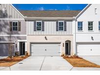 Townhome with a two-car garage, with board and batten siding with brick accents at 405 Carrera Ln, Acworth, GA 30102
