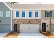 Charming townhome exterior featuring a brick facade and attached garage at 412 Carrera Ln, Acworth, GA 30102