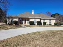 Charming single story home featuring manicured landscaping and a long, curved driveway at 1205 Dover Se Pl, Conyers, GA 30013