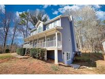 Charming two-story home featuring a covered front porch, and inviting curb appeal, nestled on a landscaped lot with mature trees at 1230 Scenic Brook Sw Trl, Conyers, GA 30094