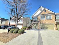 Charming two-story townhouse with attached garage and well-maintained landscaping under a bright blue sky at 2540 Willow Grove Road Nw Rd, Acworth, GA 30101