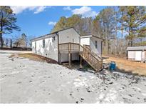 Charming white home featuring a deck and stairs to the backyard at 4064 Post Rd, Winston, GA 30187
