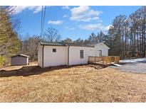 Charming white home featuring a wooden deck, green metal roof, and natural light at 4064 Post Rd, Winston, GA 30187