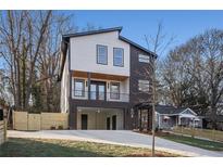 Modern two-story home featuring a sleek design, open carport, and inviting front balcony at 608 S Evelyn Nw Pl, Atlanta, GA 30318
