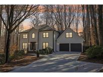 Beautiful two-story home featuring a two-car garage and manicured front yard with lush trees at 325 Upper Creek Ct, Roswell, GA 30076
