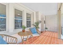Inviting covered porch featuring wicker furniture, brick accents, and ample natural light for outdoor relaxation at 1337 M L King Jr Nw Dr, Atlanta, GA 30314