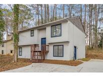 Two-story home featuring a classic exterior, blue door and window trim, wooden steps, and a well-maintained yard at 546 S Hairston Rd, Stone Mountain, GA 30088