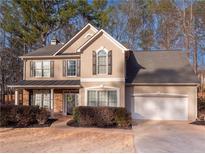Inviting two-story home with stone accents, well-manicured landscaping, and attached two-car garage at 5102 Staplehurst Ln, Woodstock, GA 30189