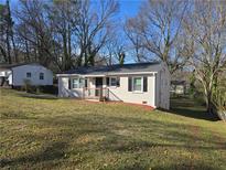 Charming single-story home with white exterior, updated windows, and manicured lawn at 938 Rebel Forest Se Dr, Atlanta, GA 30315
