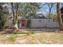 Charming one-story home with grey brick, red front door, and mature trees at 1922 Willa Dr, Decatur, GA 30032