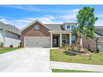 Charming brick home with a two-car garage, manicured lawn, and inviting front entrance at 163 Lorraine Pkwy, Woodstock, GA 30188