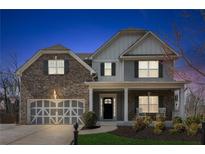 Charming two-story home featuring a brick and siding exterior, covered porch, and well-manicured front yard at 6350 Boulder Rdg, Cumming, GA 30028