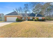 Charming single-story brick home featuring manicured landscaping and attached two car garage at 4184 Wyndham Park Cir, Decatur, GA 30034