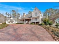 Charming white two-story home with a long front porch and a spacious driveway at 300 Mill Creek Ct, Acworth, GA 30101