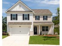 Charming two-story home with a mix of white siding and brick, featuring a two-car garage and black shutters at 6090 Zephyr Ln, Mableton, GA 30126