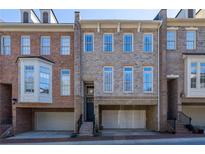 Stylish townhouse with brick and stone facade, a front-entry garage, and a classic multi-pane window design at 12 Candler Grove Dr, Decatur, GA 30030