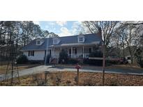 Charming single-Gathering home featuring a welcoming front porch, dormer windows, and a well-maintained lawn at 3640 Chandler Haulk Rd, Loganville, GA 30052