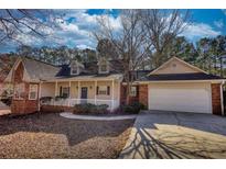 Charming single-Gathering home boasts a covered porch, brick accents and a two-car garage at 424 Cannonball Ct, Stockbridge, GA 30281
