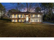Charming two-story home featuring a well-manicured lawn, brick accents, symmetrical design, and a welcoming entrance at 2390 Amberbrook Sw Dr, Conyers, GA 30094