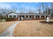 Charming brick home with a well-maintained lawn and walkway leading to a covered front porch at 4164 W Shore Ct, Douglasville, GA 30135