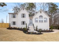 Charming two-story painted brick home with manicured front yard and inviting entrance at 101 Saddlehorn Ct, Woodstock, GA 30188