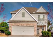 Charming two-story home with a brick facade and a two-car garage on a sunny day at 1340 Aster Ives Dr, Lawrenceville, GA 30045