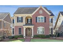 Charming two-story brick home with manicured lawn, professional landscaping, and inviting front porch at 214 Avery Ne St, Marietta, GA 30060