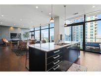 Modern kitchen with marble counters, sleek cabinetry, and floor-to-ceiling windows with city views at 45 Ivan Allen Jr Nw Blvd # 1706, Atlanta, GA 30308