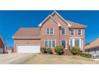 Charming two-story brick home with a well-manicured front lawn and attached two-car garage at 5594 Mountain View Pass, Stone Mountain, GA 30087