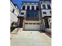 Modern townhouse with a two car garage, light colored brick and traditional siding at 1115 Rivard Nw Cir, Atlanta, GA 30318