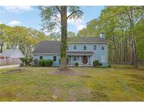 Charming two-story home features a light-blue exterior, landscaped yard, and mature trees at 3430 Pate Rd, Snellville, GA 30078