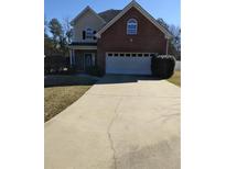 Traditional two-story brick home featuring an attached two-car garage and mature landscaping at 10 Chapman Way, Covington, GA 30016