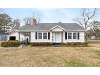 Charming single-story home with covered porch and black shutters, set on a spacious lot at 116 Poplar St, Fairburn, GA 30213