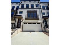 Exterior of a townhome featuring a two-car garage and a second-story balcony at 1113 Rivard Nw Cir, Atlanta, GA 30318