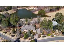 Expansive estate features a beautiful lake view, mature trees, and meticulously landscaped grounds at 939 Middle Fork Trl, Suwanee, GA 30024