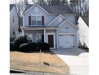 Two-story home featuring light blue siding, dark trim, and an attached one car garage at 235 Woodland Way, Canton, GA 30114